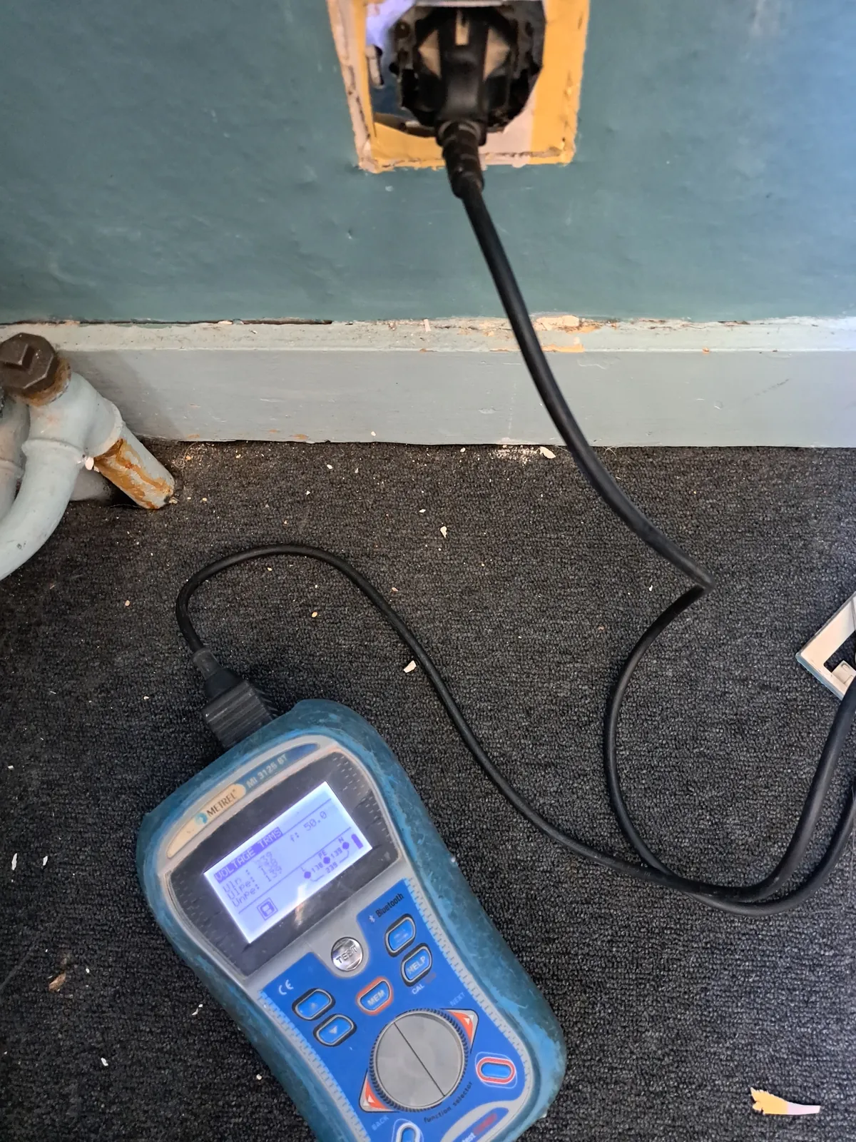 Installatietester aangesloten op een stopcontact om de aarding te meten