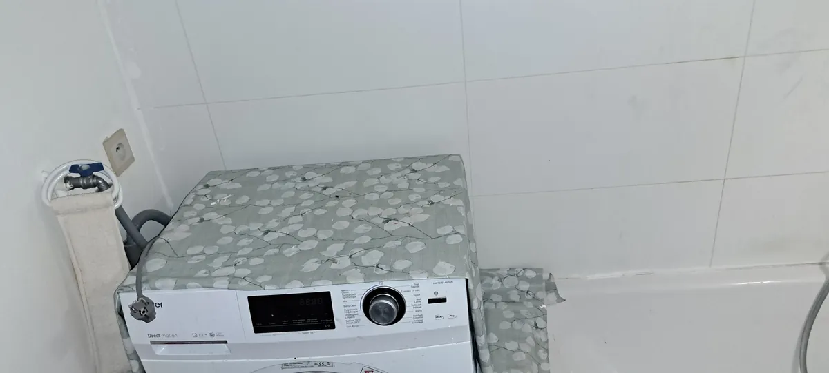 Wasmachine in volume 2 van de badkamer, naast het bad